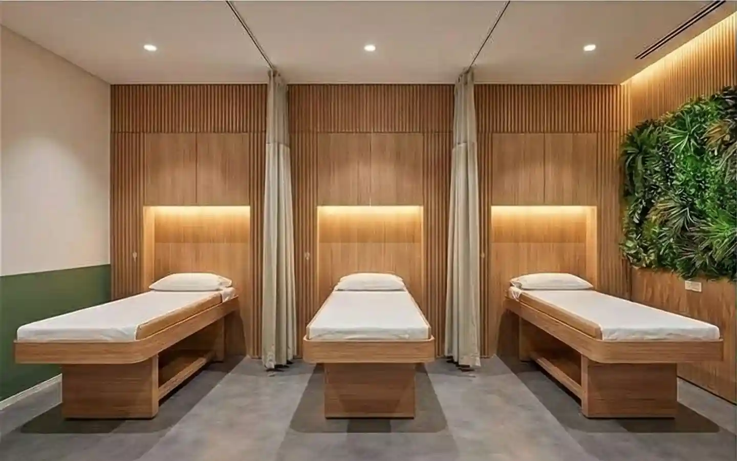 Luxury medical recovery room featuring wooden slat wall panels, integrated vertical greenery garden, and custom timber treatment beds with warm ambient lighting