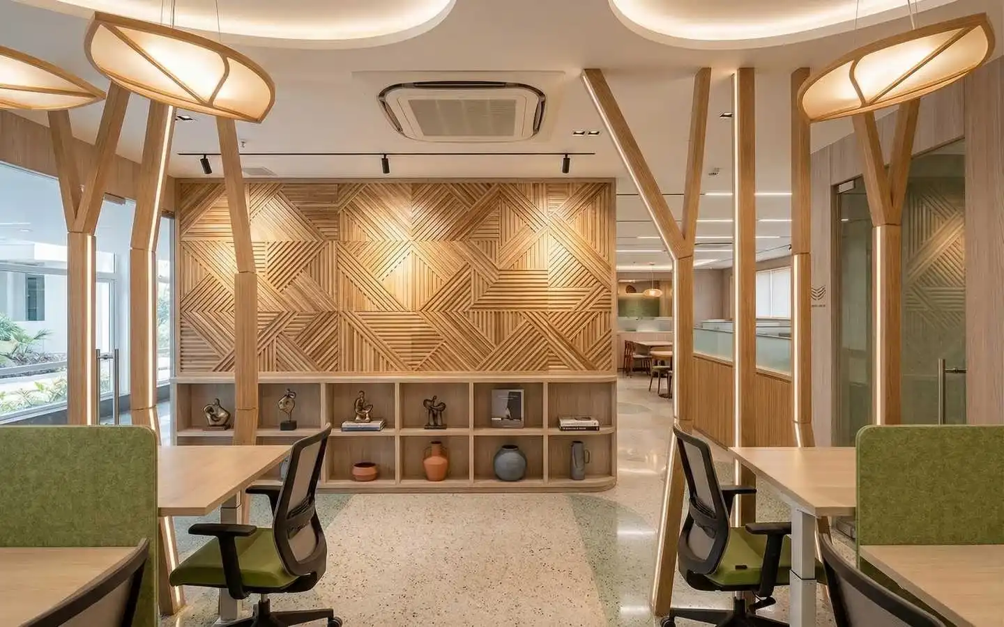 Professional office workspace featuring a geometric wood slat feature wall, custom tree-inspired pillars with integrated lighting, and ergonomic workstations