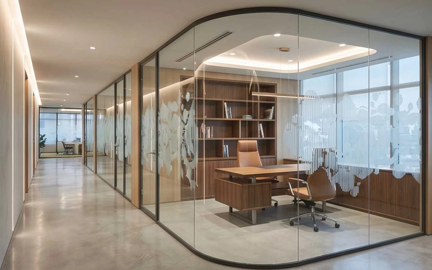 Luxury executive private office with a curved glass partition, walnut wood desk and shelving, tan leather chairs, and minimalist corridor lighting