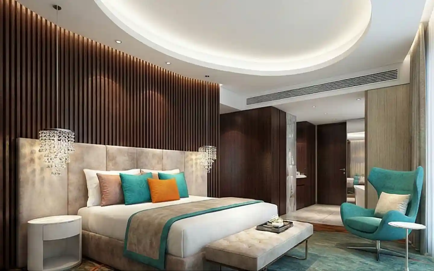 Luxury hotel bedroom featuring a fluted wood accent wall, circular recessed ceiling light, crystal bedside pendants, and a teal wingback chair