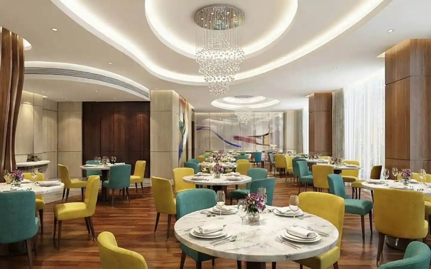 Upscale hotel dining room featuring circular marble tables, yellow and teal velvet chairs, and elegant crystal chandeliers on a recessed ceiling