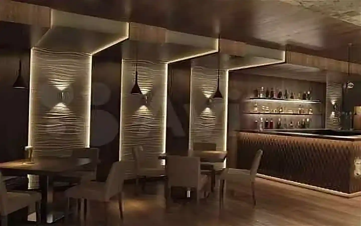 Modern luxury bar interior featuring textured 3D wall panels, warm ambient cove lighting, and elegant lounge seating