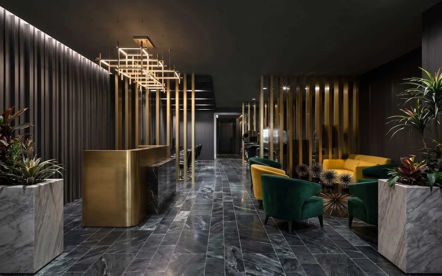 Luxury dark-themed salon interior featuring a gold reception desk, marble flooring, and elegant velvet lounge seating in green and yellow