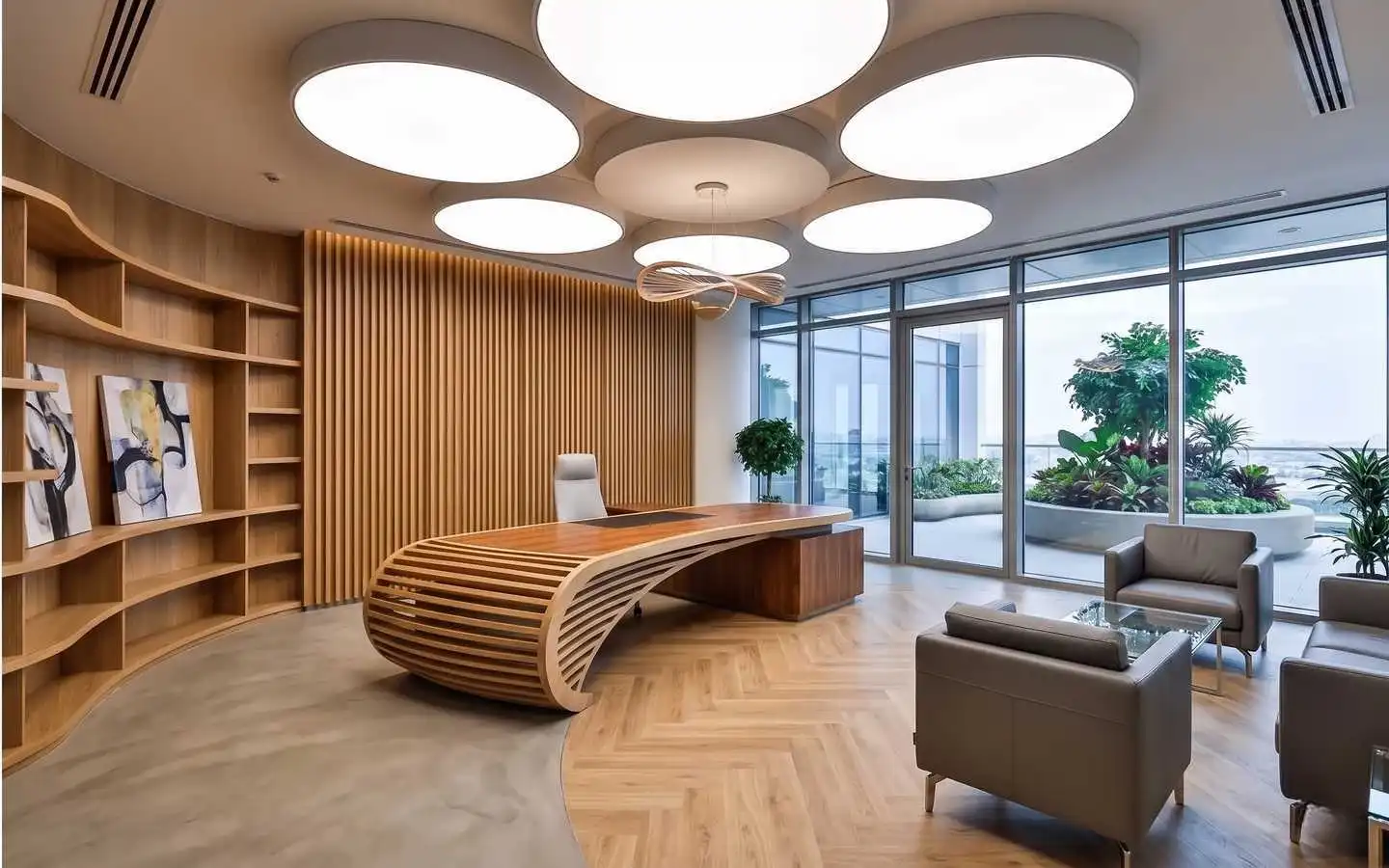Luxury executive office interior featuring a bespoke curved wood slat desk, vertical wood wall paneling, herringbone flooring, and large circular ceiling light fixtures