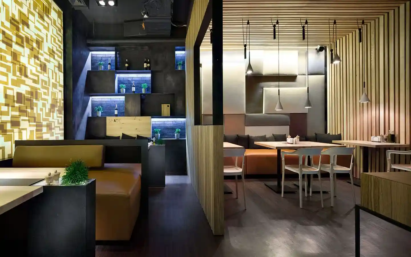 Luxury restaurant interior featuring vertical wood slat partitions, decorative backlit wall panels, acoustic ceiling baffles, and modern booth seating with warm ambient lighting