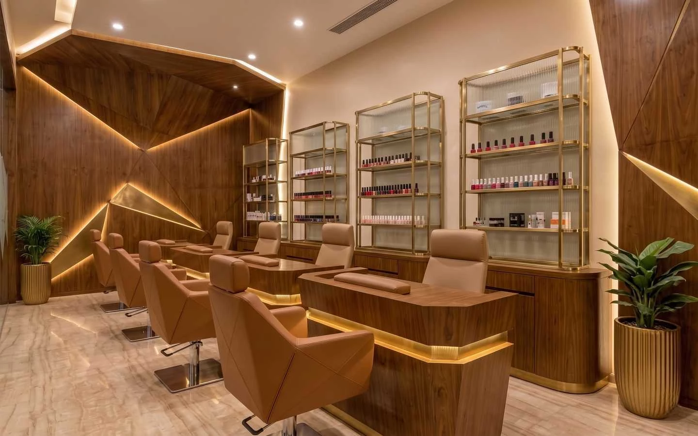 Luxury nail salon interior with geometric wood paneling, gold-accented product shelving, and ergonomic tan leather manicure stations