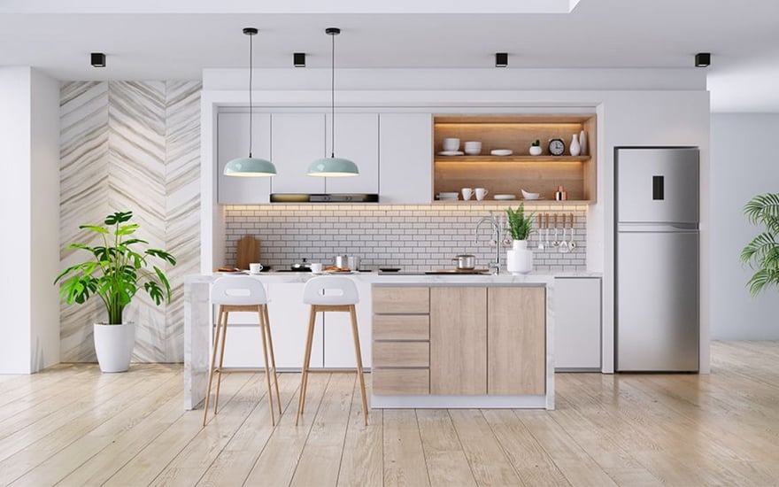 Minimalist kitchen interior featuring white cabinetry, light wood accents, a marble breakfast bar with two white stools, mint green pendant lights, and a white subway tile backsplash