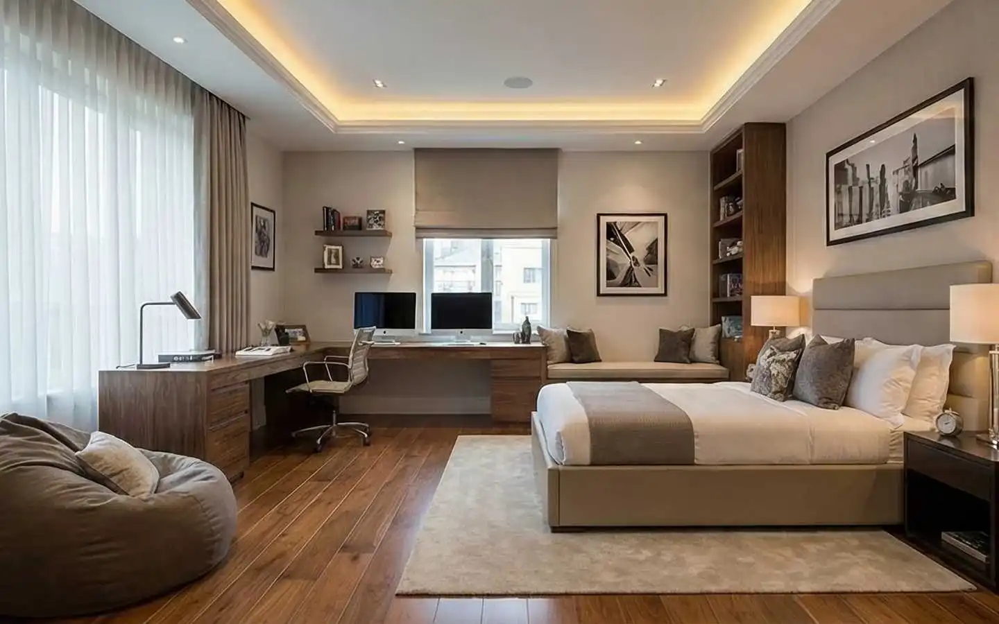 Modern luxury bedroom featuring a built-in walnut L-shaped desk with dual monitors, a cozy window seat, and a contemporary bed with recessed ceiling lighting
