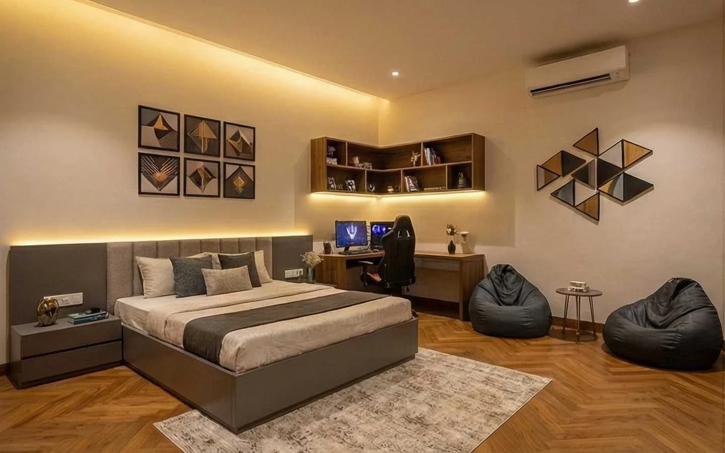 Modern bedroom interior featuring a combined workspace with an L-shaped floating bookshelf, integrated ambient lighting, a grey tufted headboard, and two black bean bags on oak chevron wood flooring