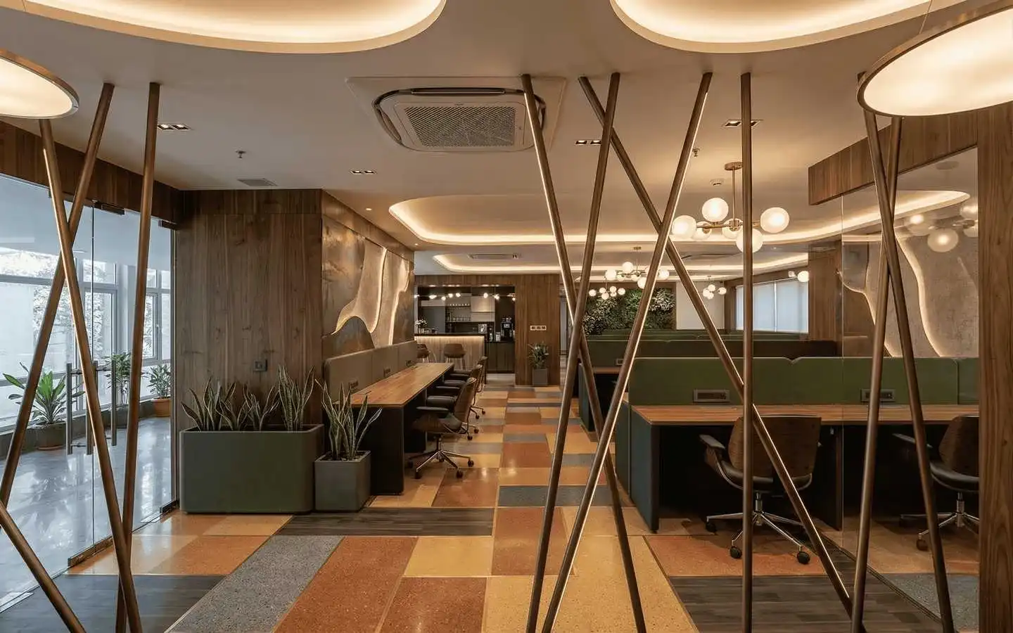 Modern commercial office interior design featuring an open workspace with desks, geometric patterned flooring, warm wood paneling, and unique angled metal room dividers