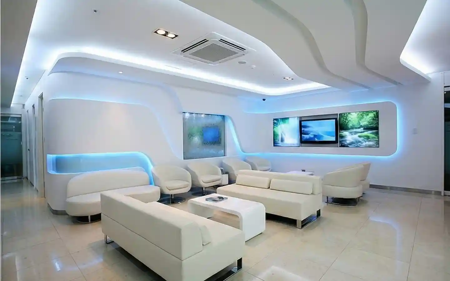 Modern luxury dental clinic waiting room featuring white curved sofas, futuristic blue LED cove lighting, and minimalist interior decor