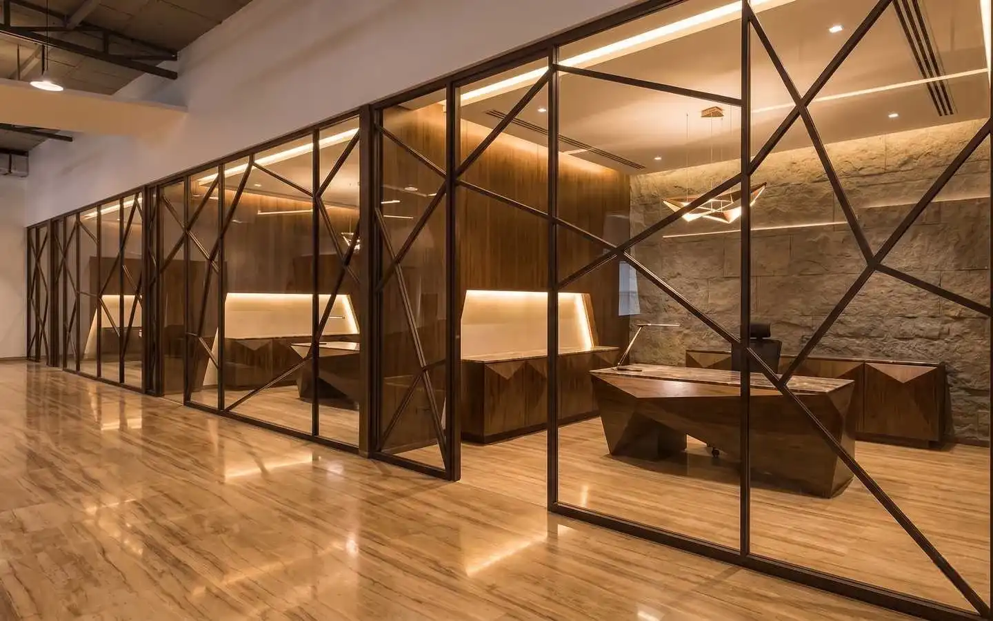 Luxury commercial interior design featuring a modern executive office with geometric glass partitions, custom wood cabinetry, and a stone accent wall