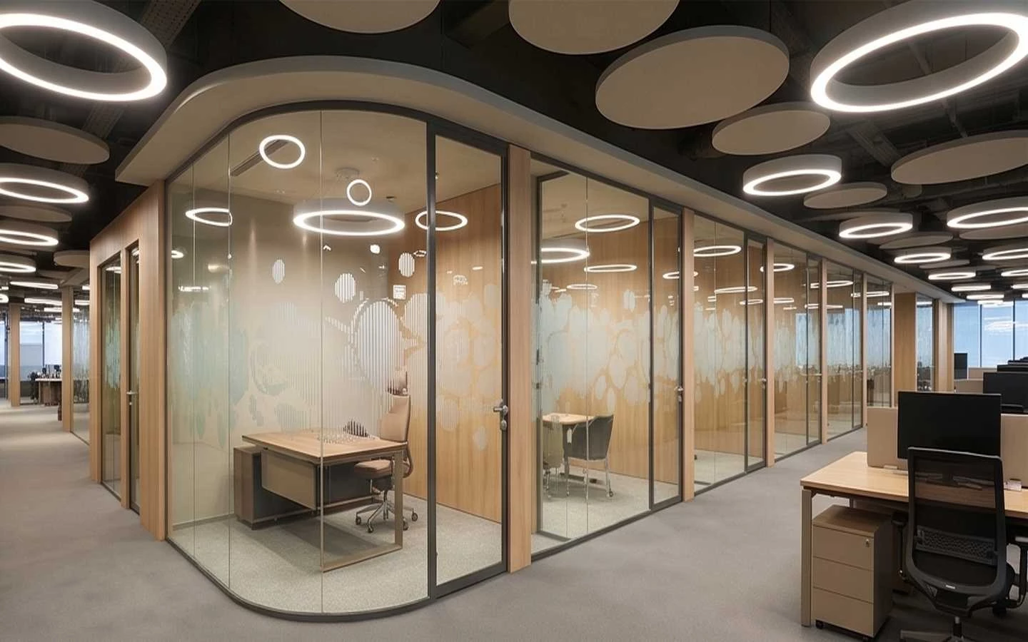 Modern office interior featuring curved glass partitions for private cabins, circular LED pendant lights, and ergonomic workstations in a corporate setting