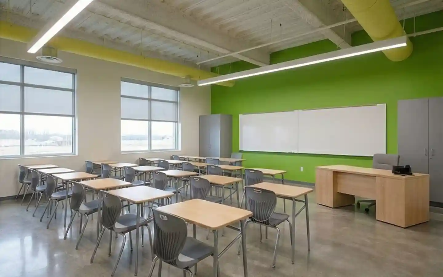 Modern high school classroom interior with ergonomic student desks, lime green accent wall, and professional teacher workstation
