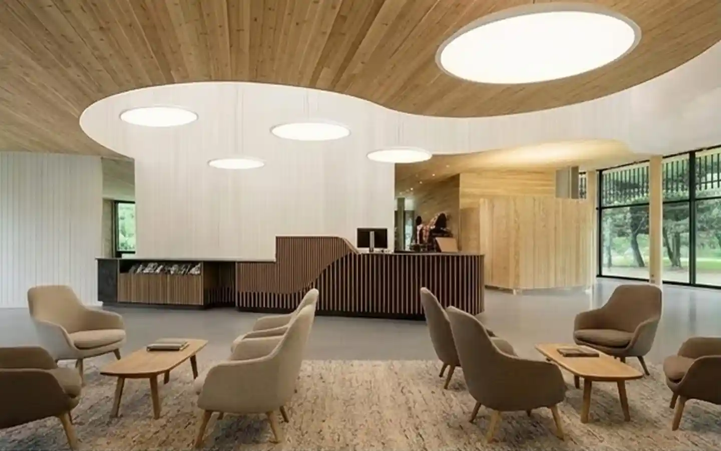 Modern hotel lobby featuring a curved wooden ceiling, minimalist reception desk, and designer lounge seating