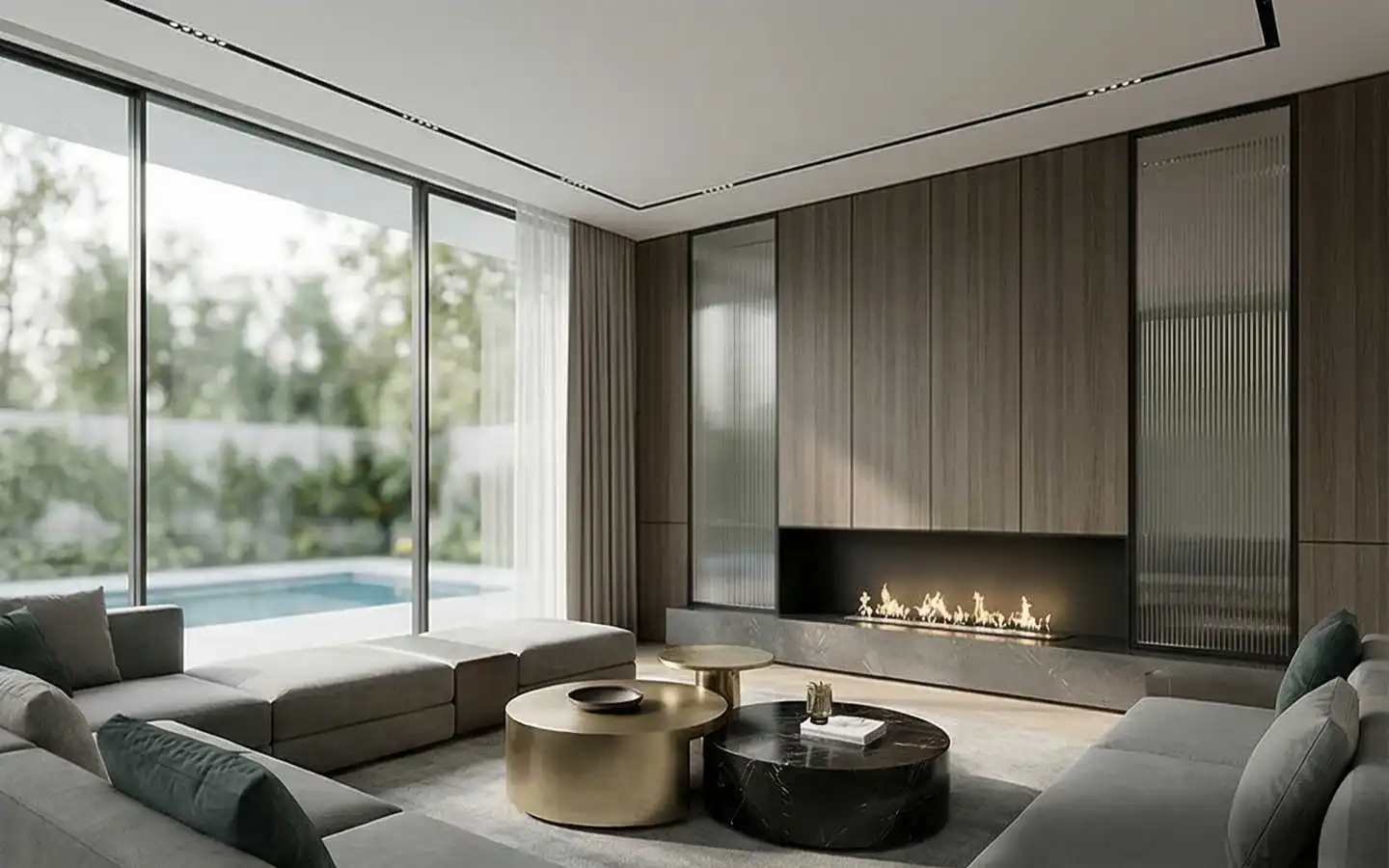 Contemporary living room interior featuring a long linear gas fireplace, wood wall paneling, modular grey sofas, and floor-to-ceiling windows overlooking a swimming pool
