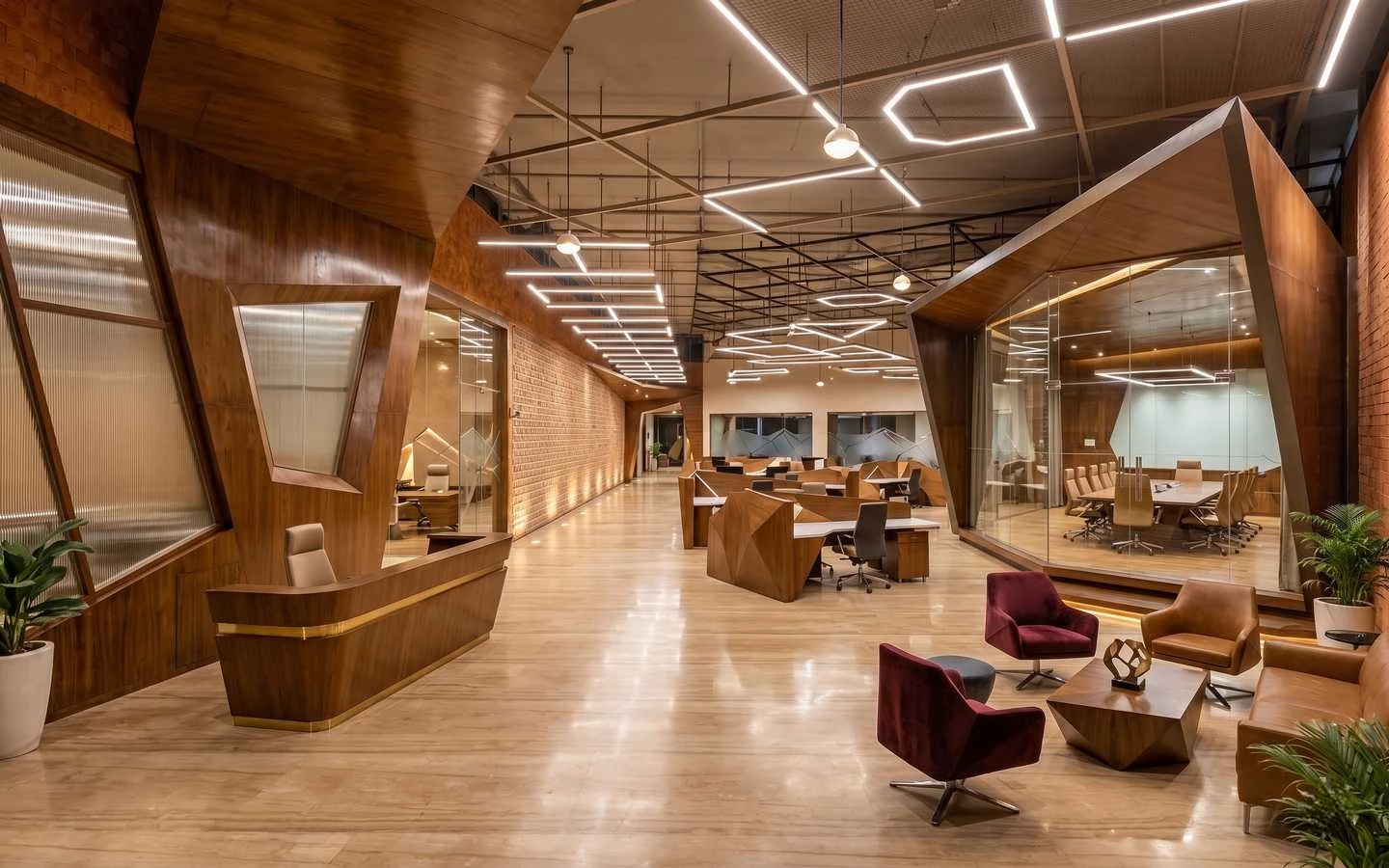 Modern luxury office interior design featuring geometric wood paneling, open workspace desks, and a glass-enclosed conference room