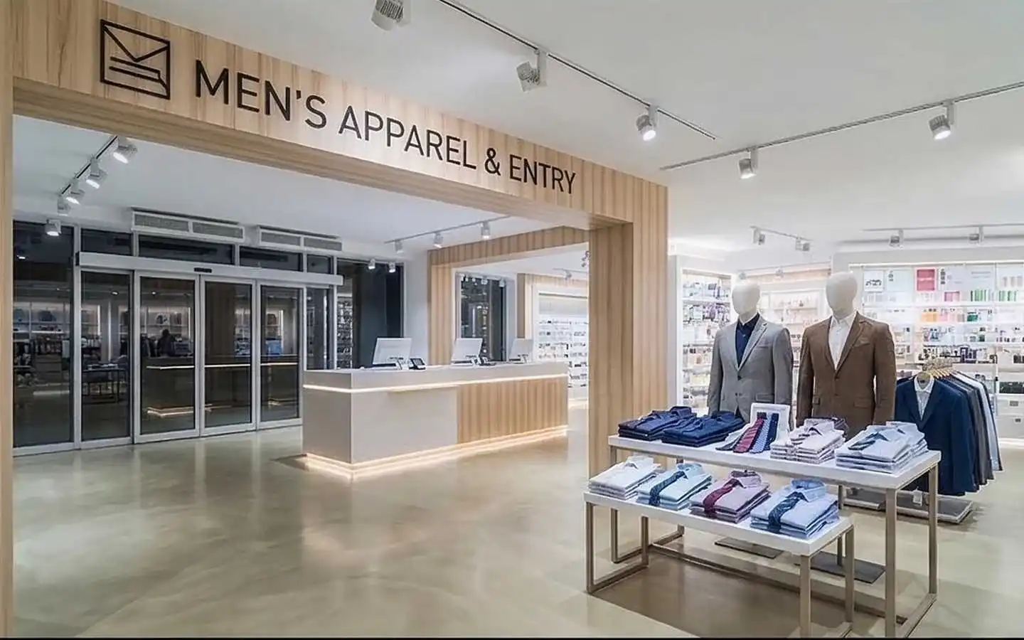 Modern men's apparel showroom interior featuring wood paneled entry, minimalist reception desk, and organized clothing displays
