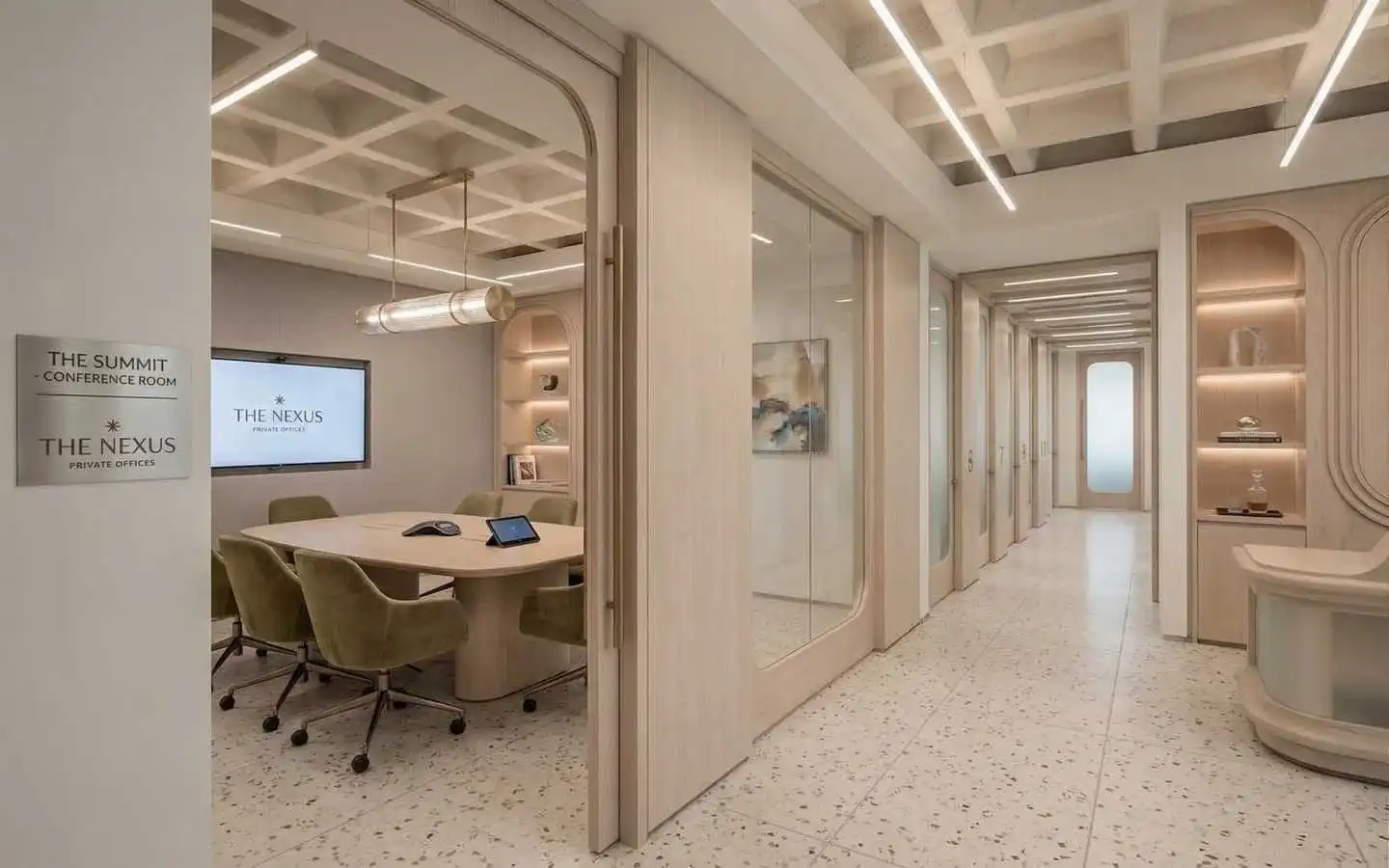 Modern office conference room with rectangular table, green swivel chairs, video conferencing screen, glass private offices along corridor, terrazzo flooring, and ambient ceiling lighting