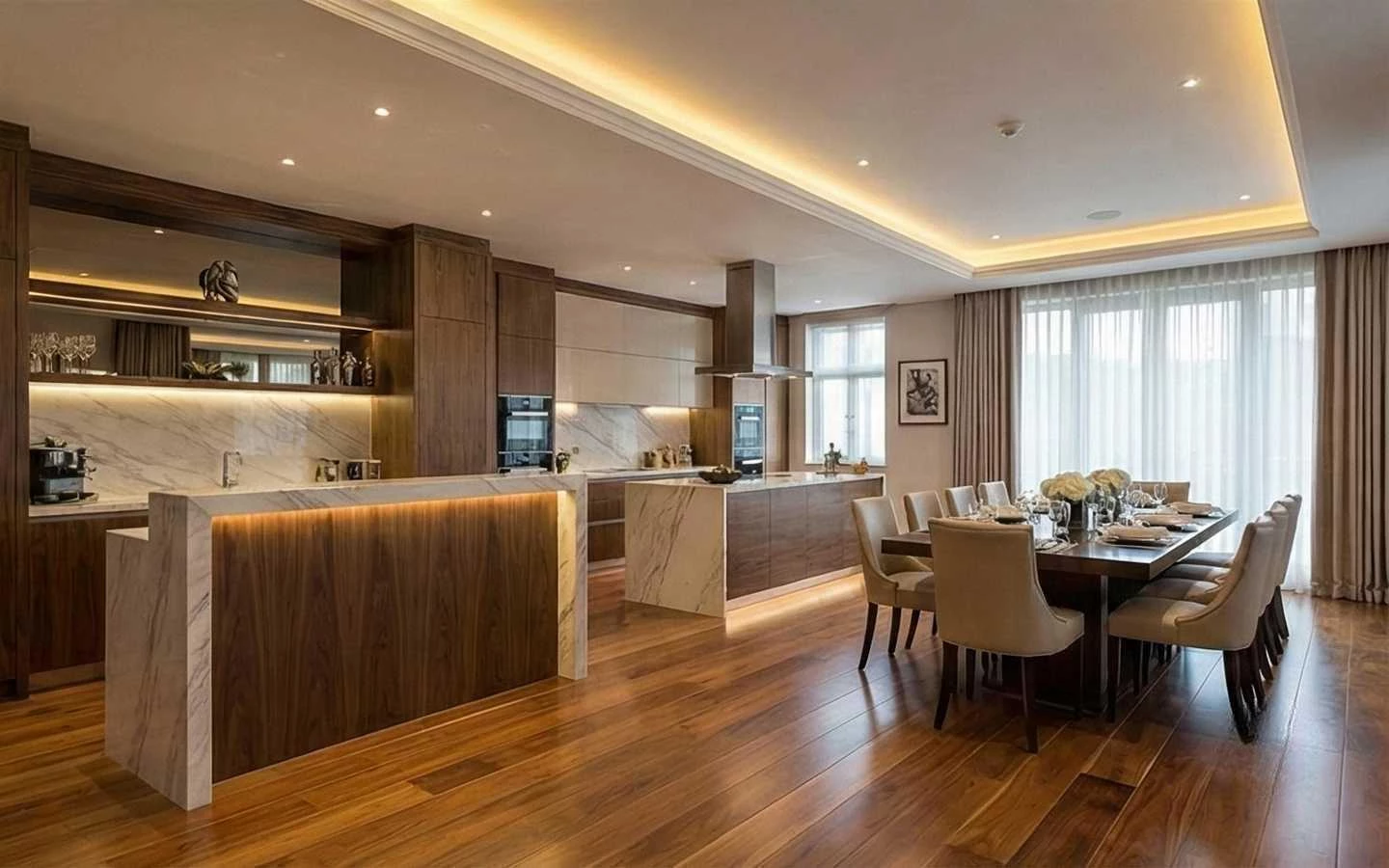 Modern open-plan kitchen and dining area featuring dual marble-topped islands, dark wood cabinetry with under-cabinet lighting, and an elegant long dining table with cream upholstered chairs