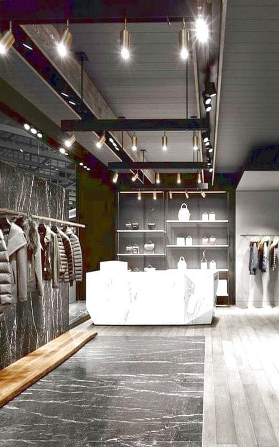 Stylish retail clothing store interior with marble counter, coat display, handbag shelves, accent lighting, and contemporary design