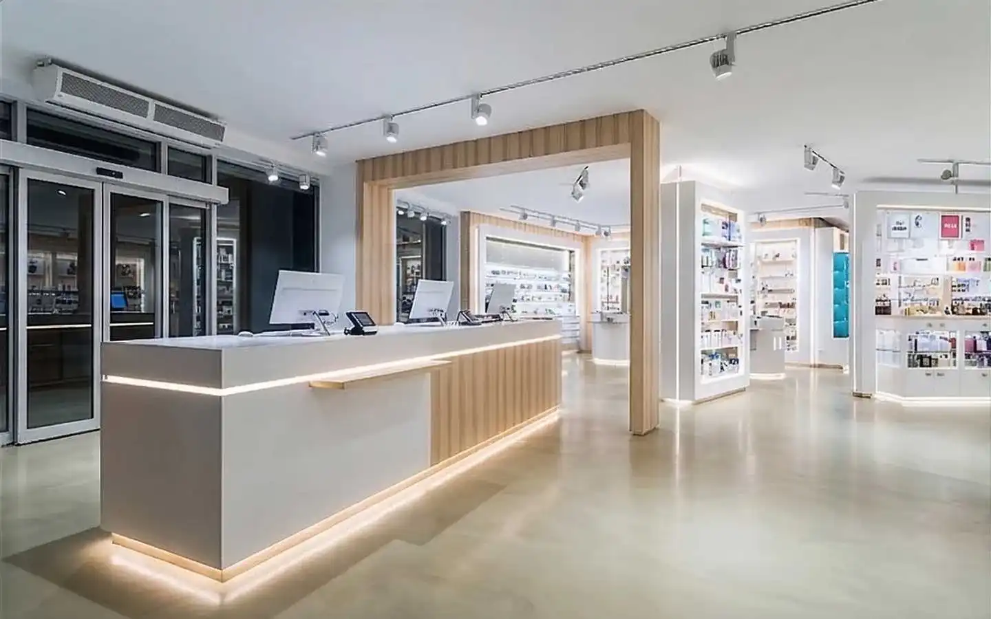 Modern retail showroom interior featuring a minimalist white and wood reception desk with LED accent lighting and organized product display shelves
