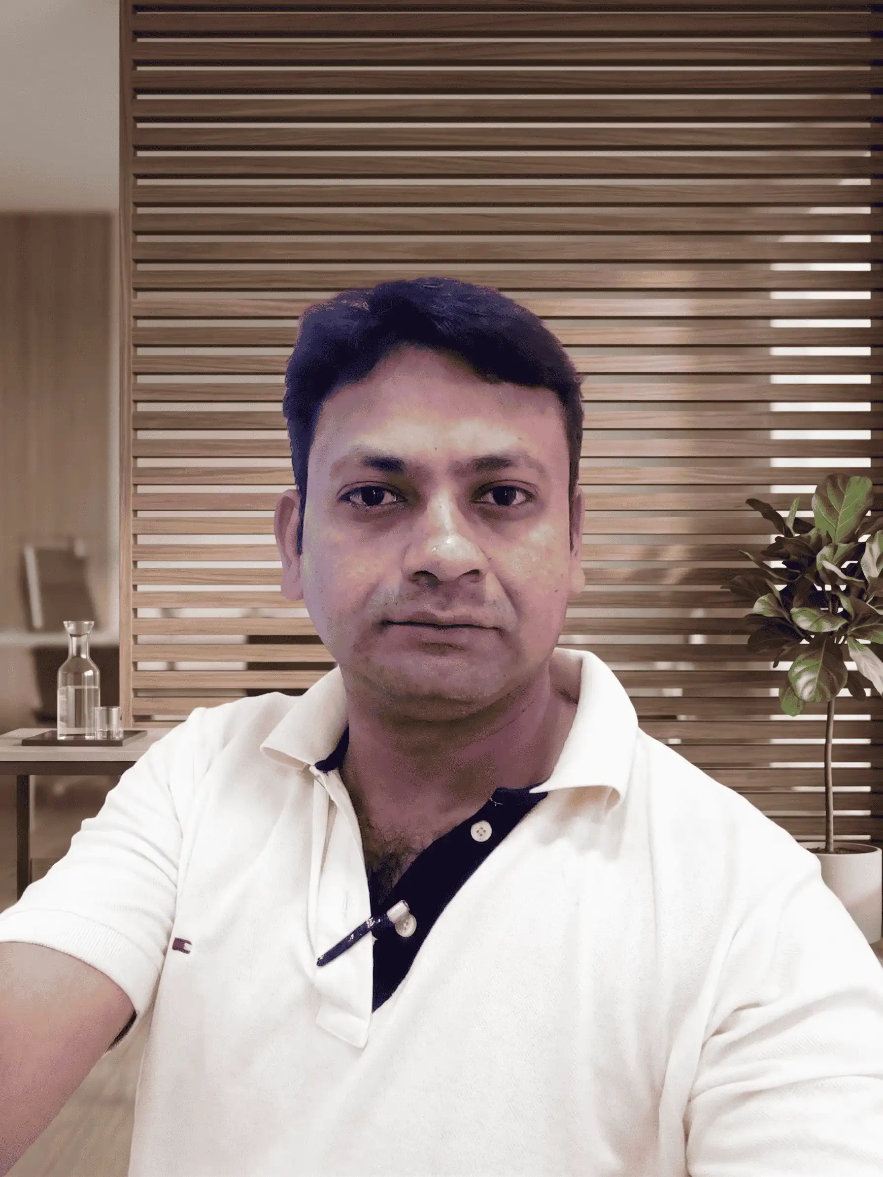 Rashid Ali, owner of 4 Lotus Interior, posing in a modern office with wooden slat partitions for The Rashid Vision