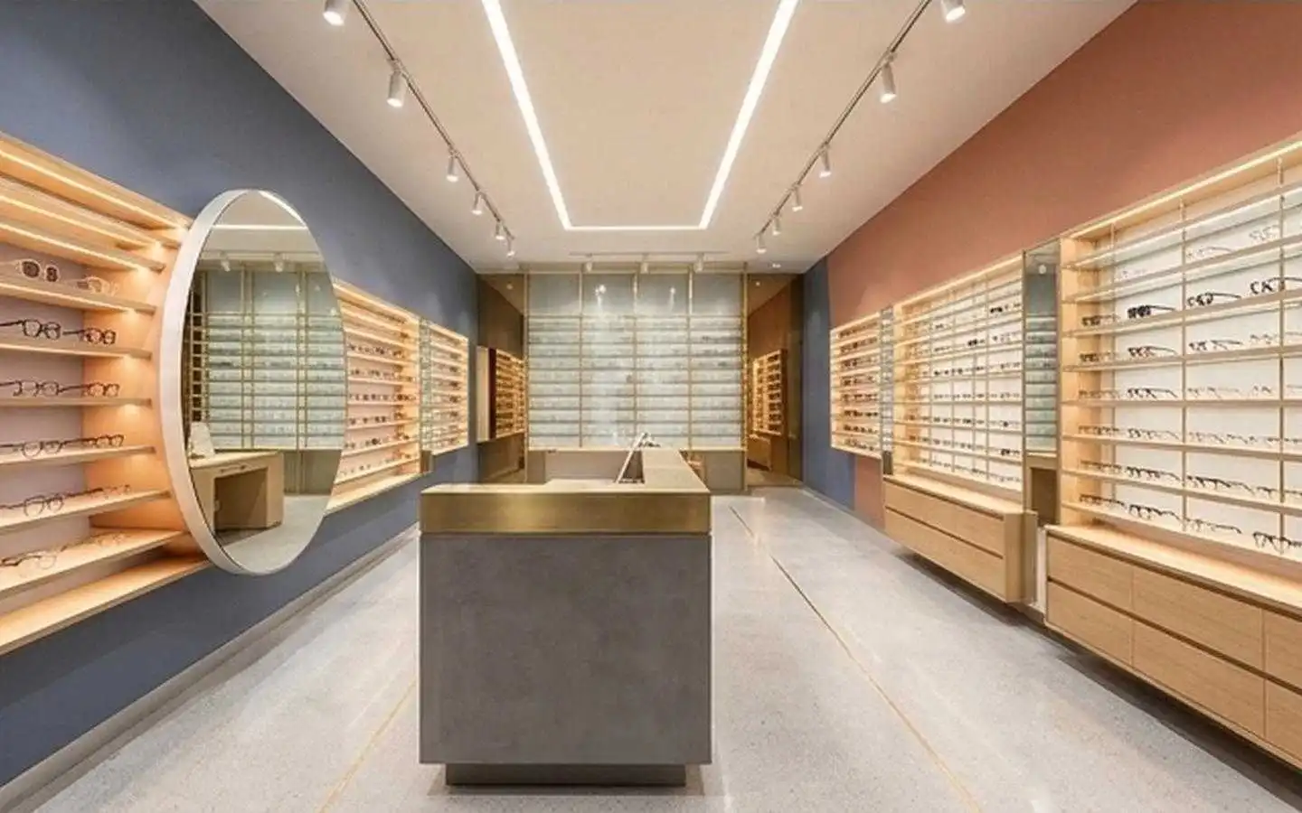 Modern optical retail showroom interior design in Delhi featuring minimalist wooden display shelves, a large circular mirror, and sleek track lighting